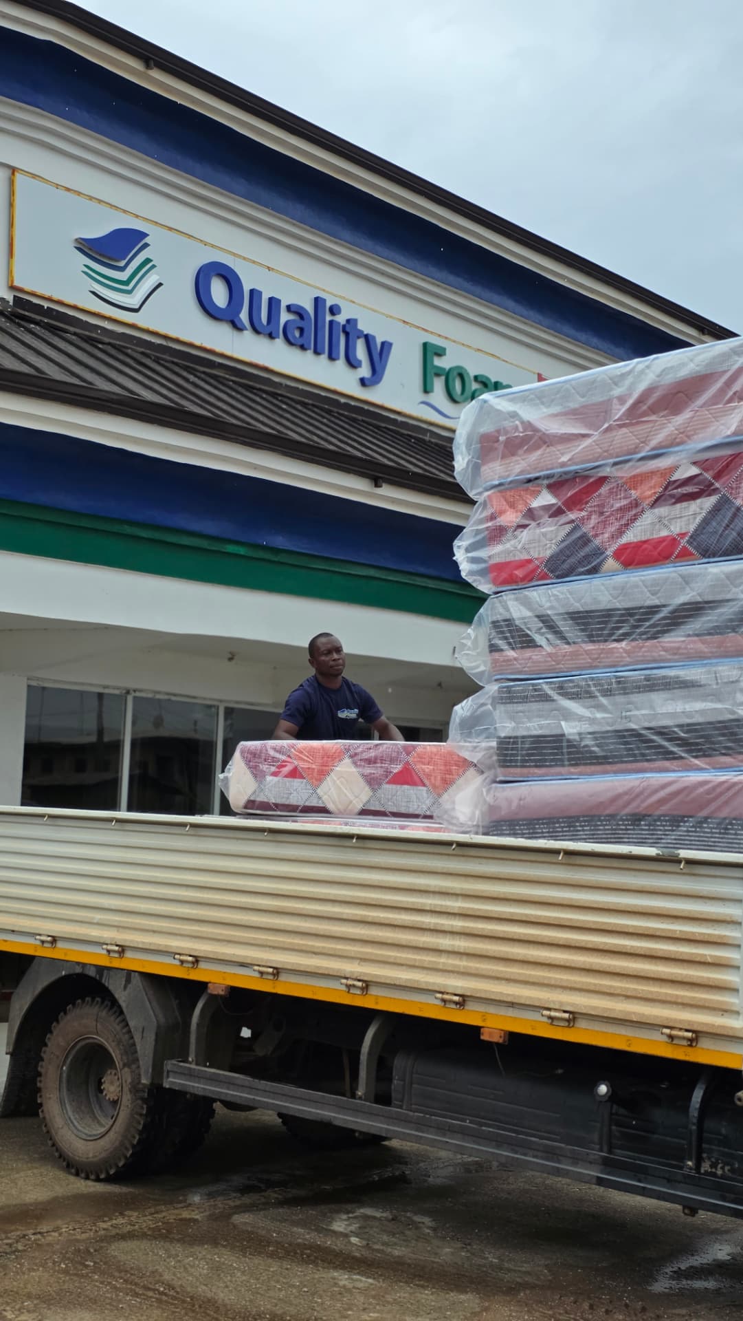Truck being loaded with mattresses in front of the Quality Foam showroom